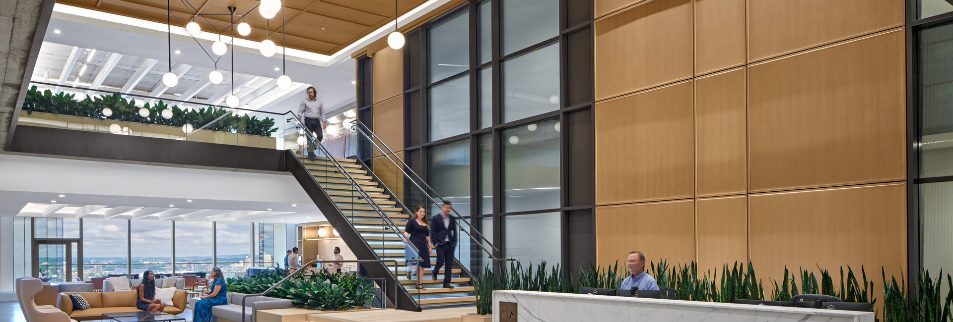 Modern lobby with staircase and large window, elegant interior with natural lighting.