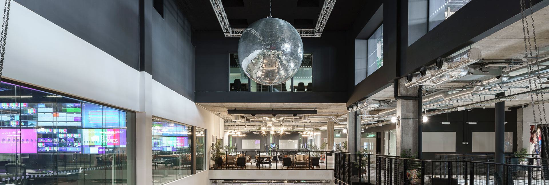 The atrium of the Riot Games building with a large disco ball hanging overhead.