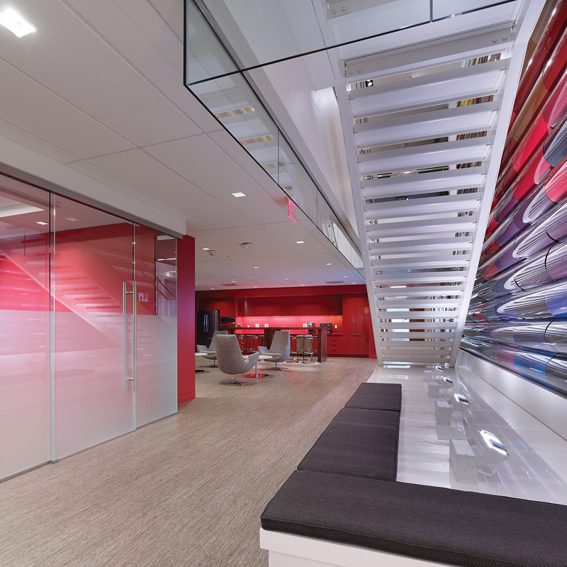 Axalta's modern office with red and white walls, featuring sleek furniture and ample natural light.