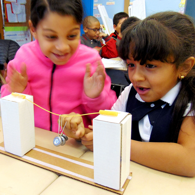 Two girls creating a bridge at NYC Salvadori Center
