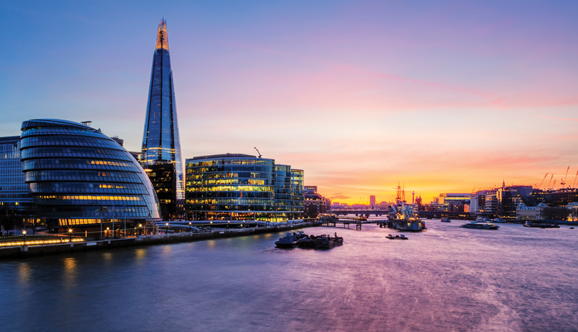 A view of London overlooking the water during sunset.