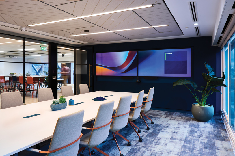 A well-equipped conference room with a large screen and seating arrangements for effective discussions and presentations at Structure Tone London's new office.