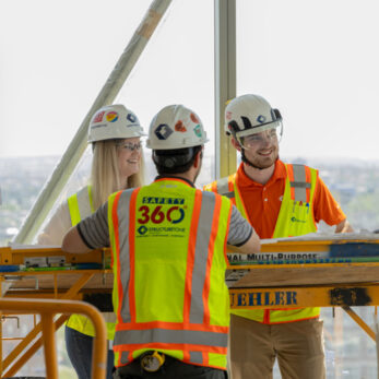 Structure Tone employees on a construction project site wearing full personal protective equipment.