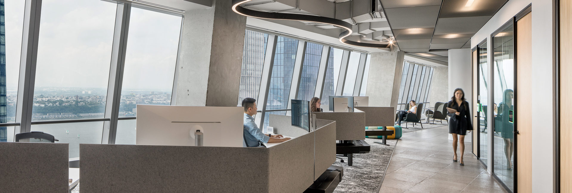 Open concept cubicles lined up next to the windows