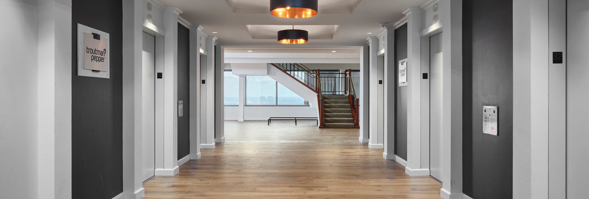 Hallway with elevators leading into an empty office space