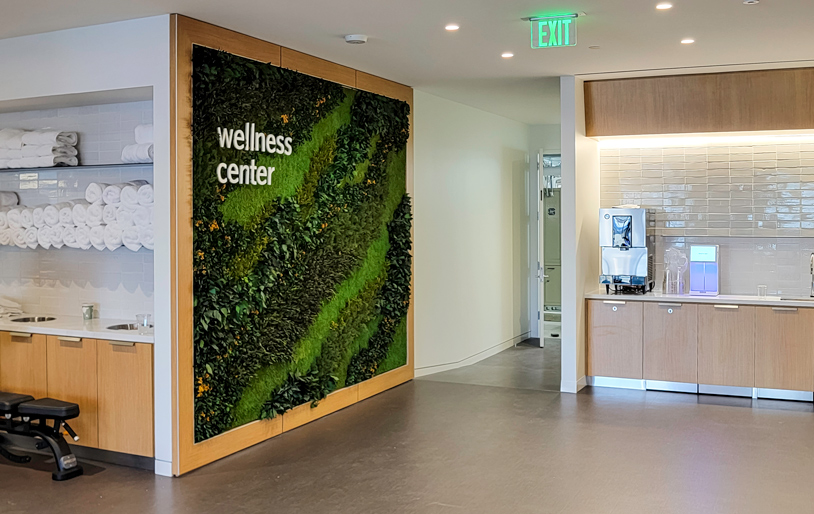 Inside the wellness center with a green feature wall and hydrations station.