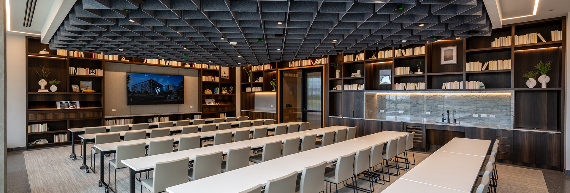 Large conference room with rows of tables and chairs facing the front