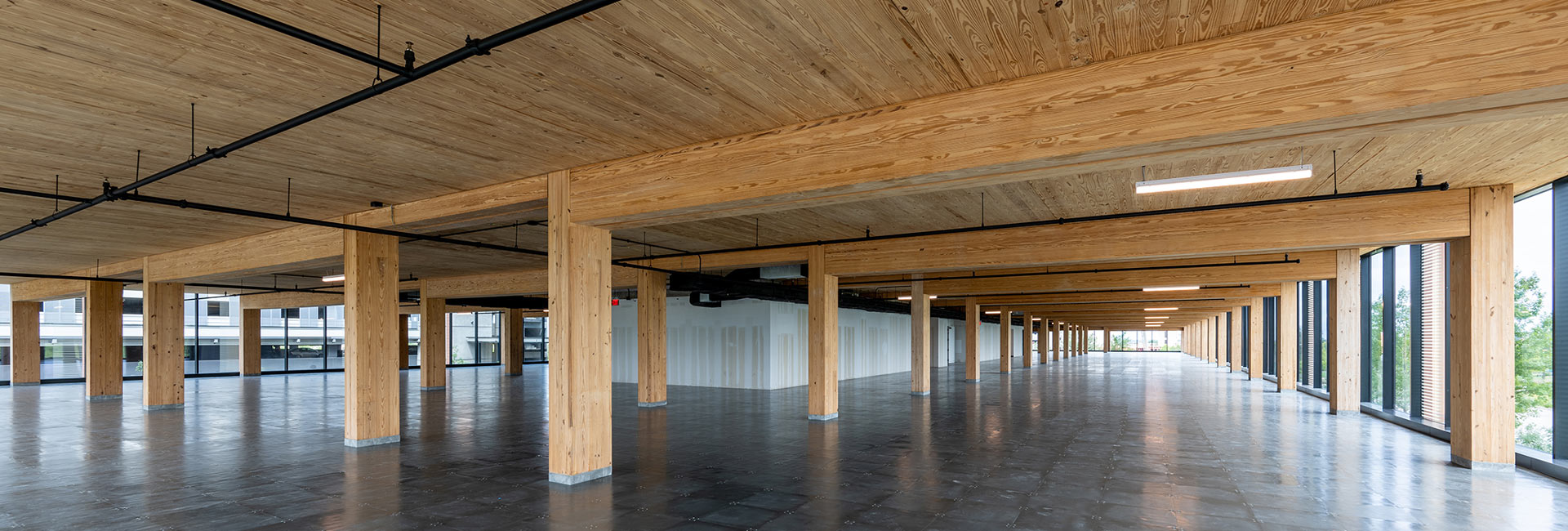 Large empty office space with wood beams and ceiling