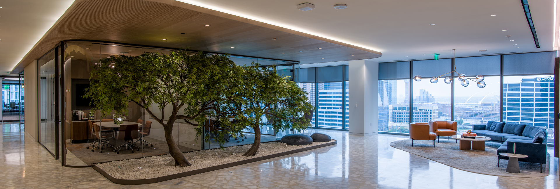 Law office interior with trees as a green feature and floor to ceiling windows and walls.