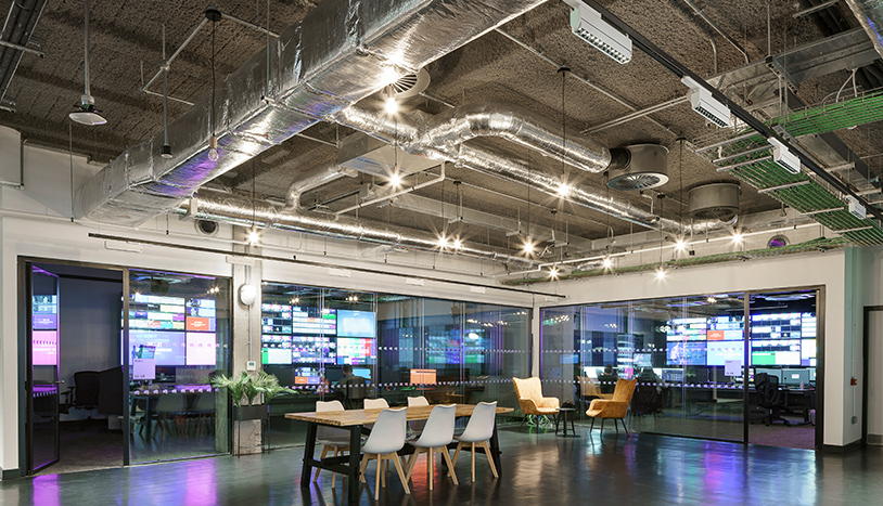 An open area with an office space that has table and chairs