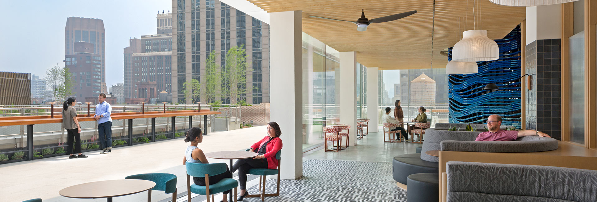 An outdoor space with tables and chairs for employees to enjoy overlooking NYC.