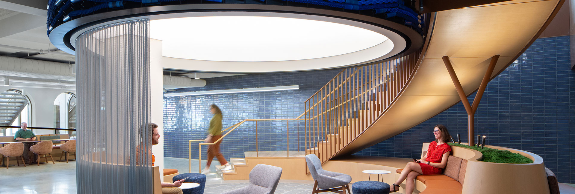 Spiral staircase leading to an open area with ample chairs for collaboration.