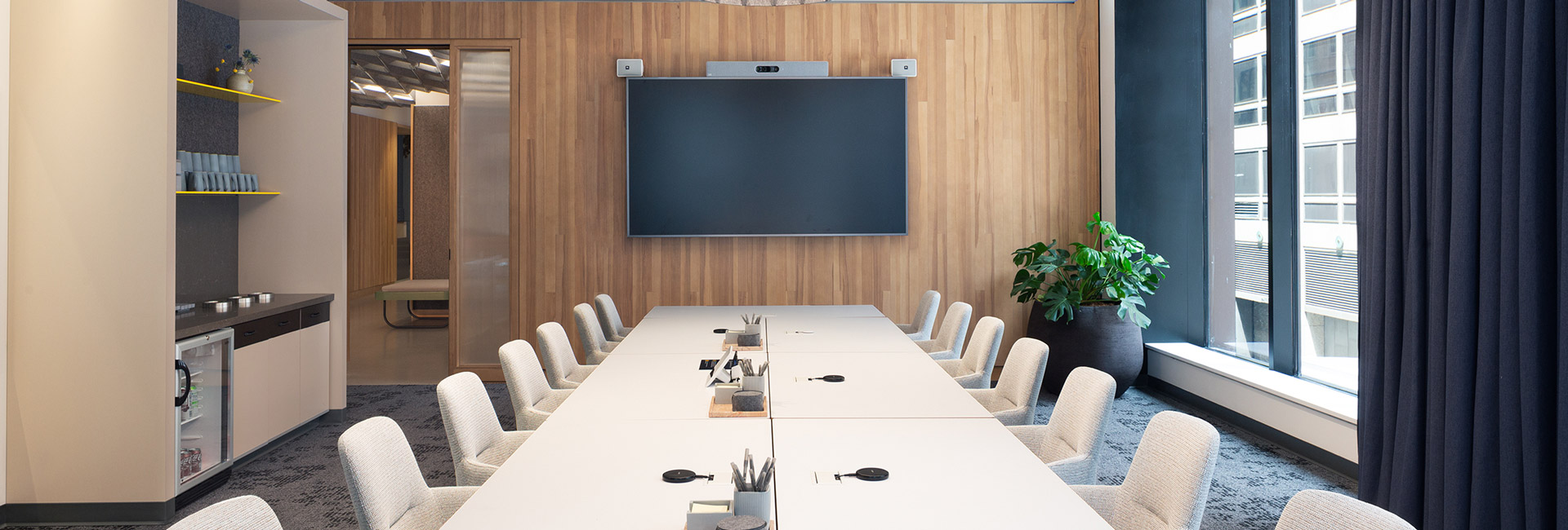 A large conference room with a long white table and chairs.