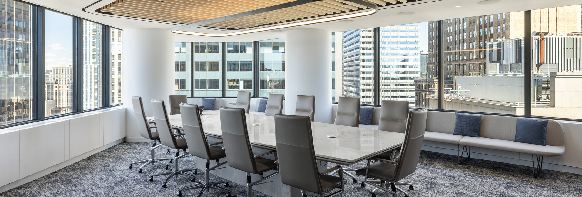 Large conference room with windows all around overlooking the New York City skyline.