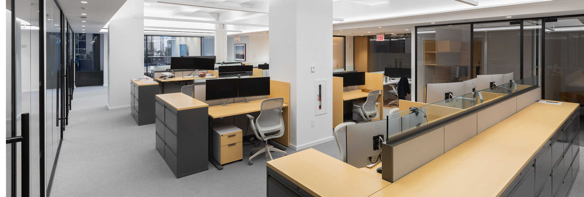 Rows of open office desks with computers