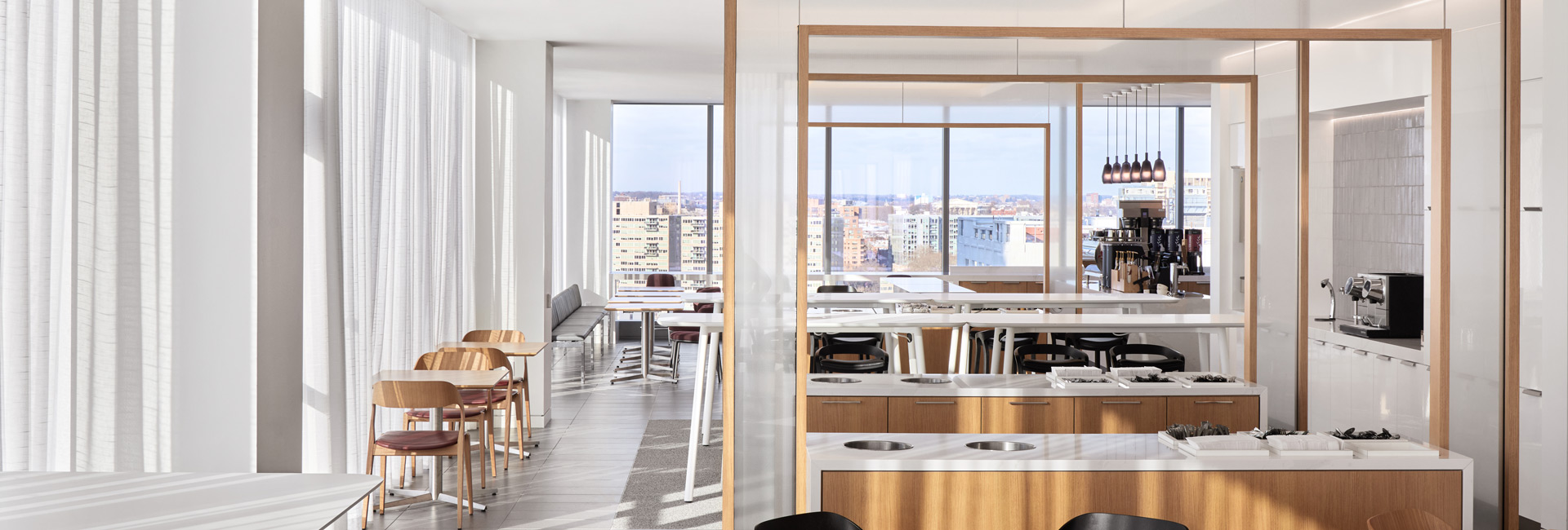 A contemporary office featuring a spacious window and buffet tables for dining.