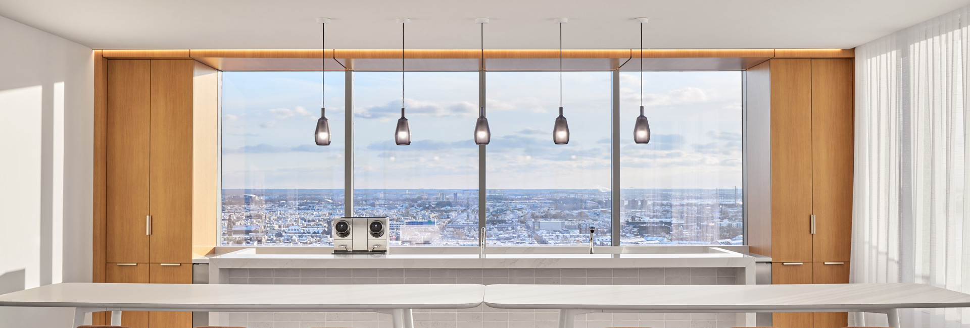 A modern kitchen featuring large windows that showcase a stunning view of the city skyline.