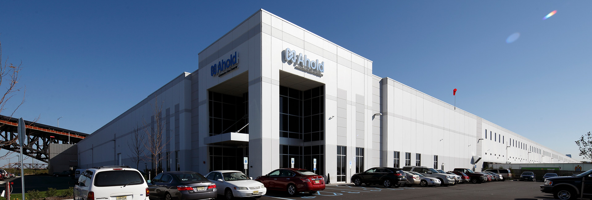 A large white warehouse building stands prominently against a lush green lawn, creating a serene and inviting atmosphere.