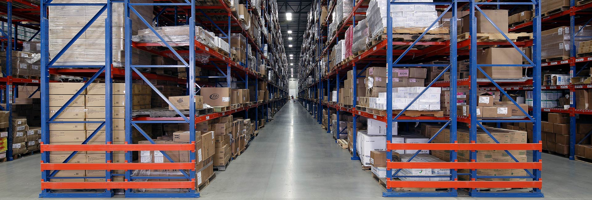 A spacious warehouse filled with numerous boxes stacked on shelves, showcasing an organized storage environment.