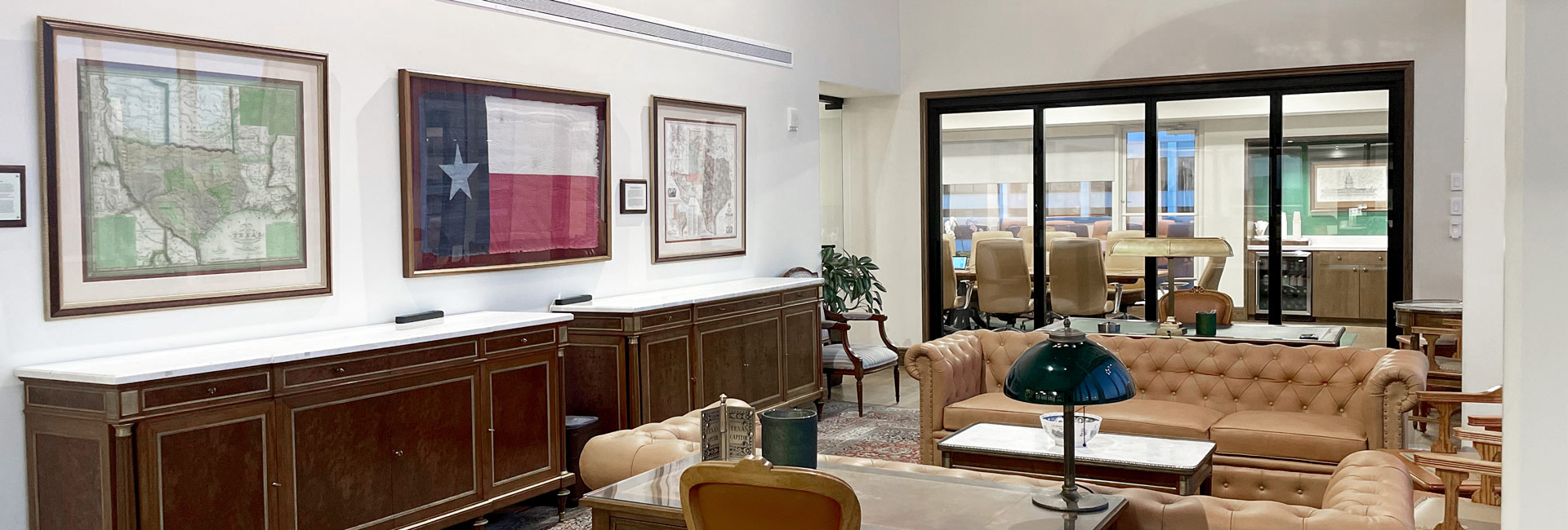 A well-furnished law office showcasing a plush couch, a modern coffee table, and pictures hanging above.