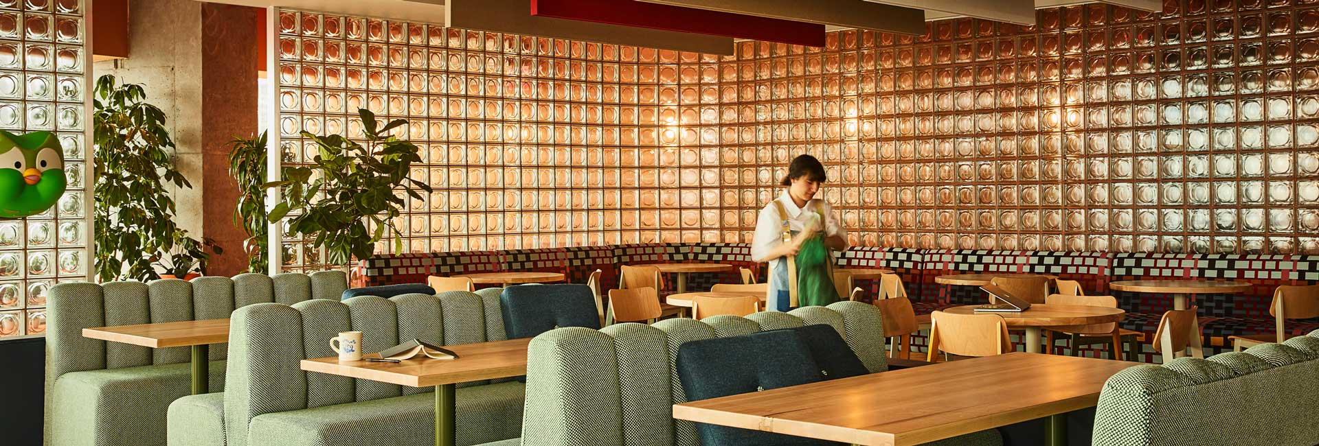 A vibrant restaurant featuring green and blue chairs and tables, creating a lively and inviting atmosphere for diners.