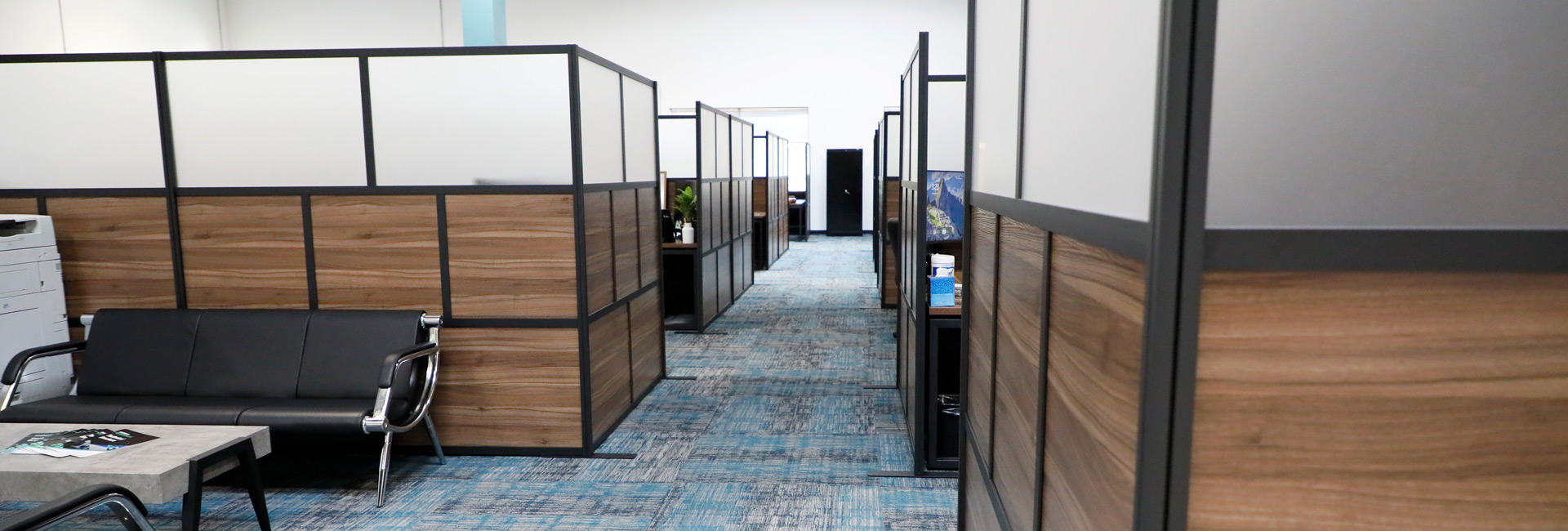 An office space featuring a central desk surrounded by chairs, creating a functional work environment.