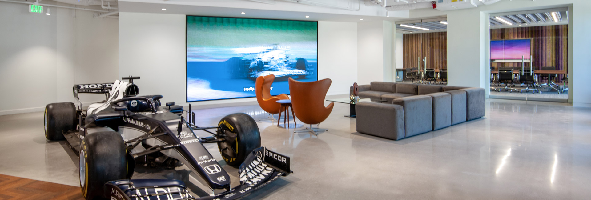 A sleek race car showcased in a contemporary office setting, highlighting a blend of speed and modern design.