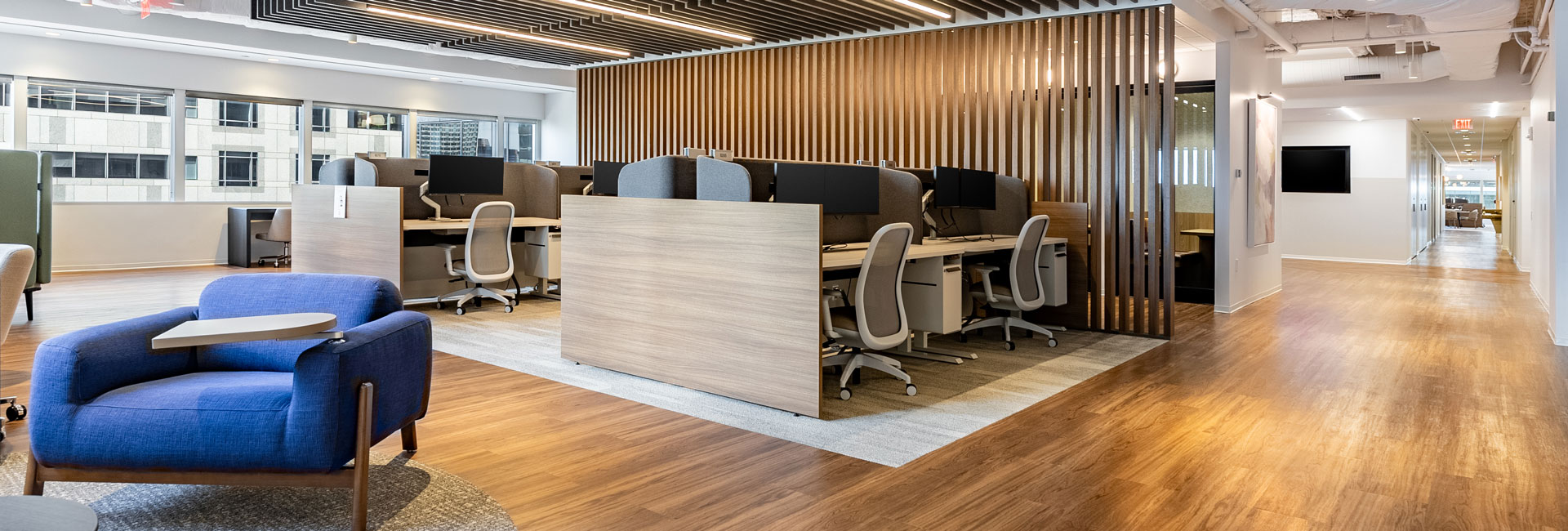 A professional office space with polished wooden floors and stylish blue chairs, enhancing the overall aesthetic.