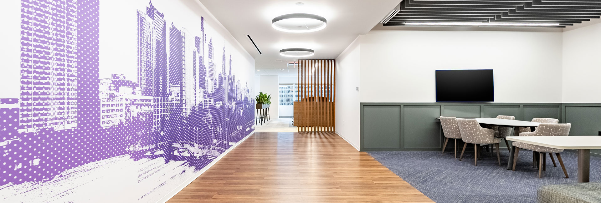 A stylish modern office characterized by purple walls and polished wooden floors, offering a dynamic work environment.