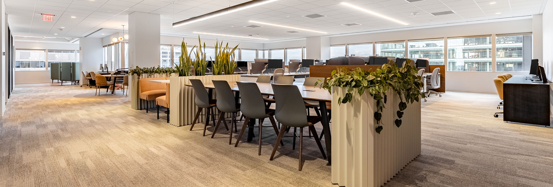 A spacious office featuring a large table surrounded by several chairs, designed for meetings and collaborative work.