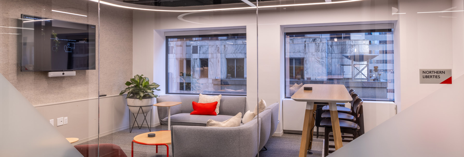 A modern office featuring a couch, coffee table, and television, creating a comfortable and inviting workspace.