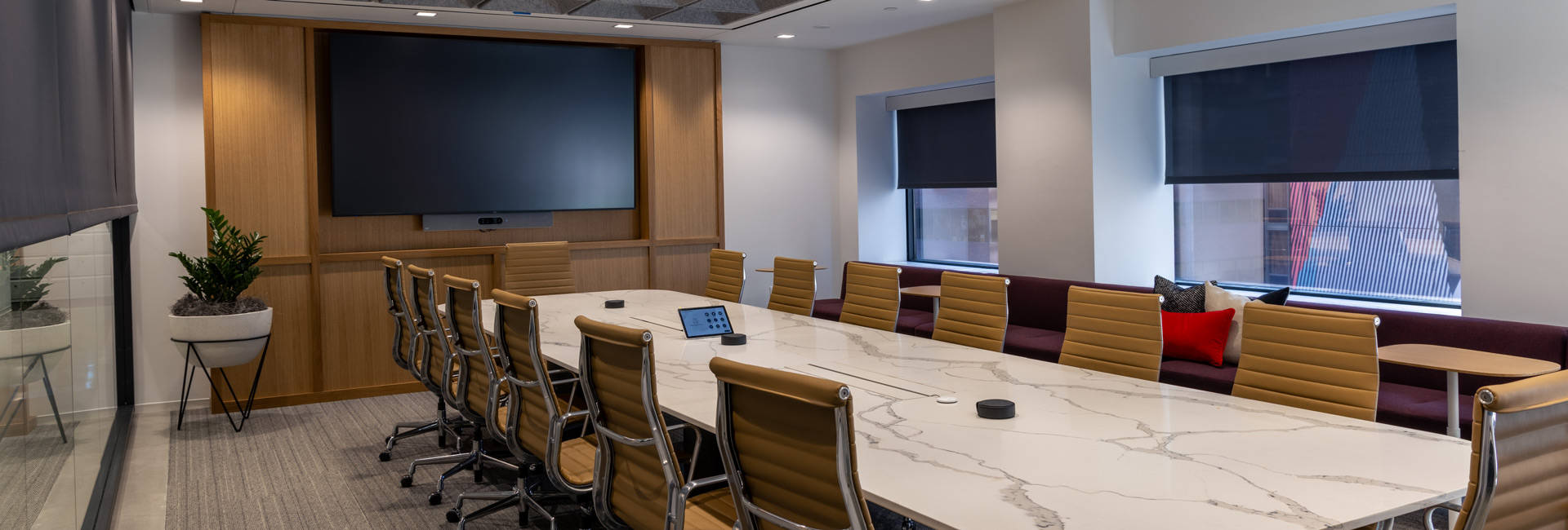 A spacious conference room featuring a large table surrounded by several chairs.