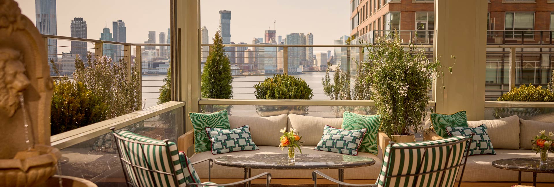 Rooftop terrace at a New York hotel, featuring city skyline views and outdoor seating for guests to enjoy.