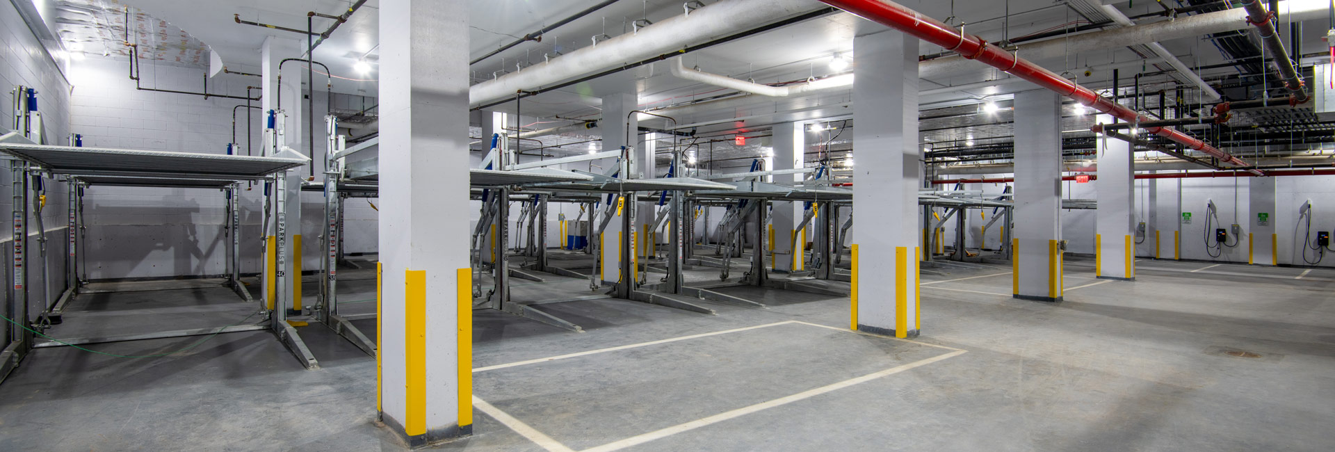A spacious garage filled with multiple rows of metal storage racks, organized for efficient car parking.
