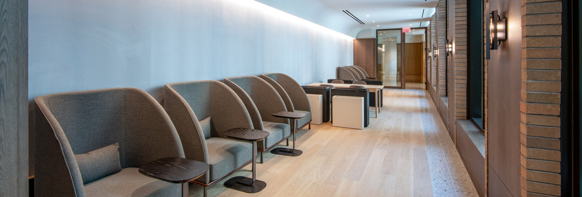 A long hallway featuring rows of chairs and tables along the sides, creating a spacious and inviting atmosphere.