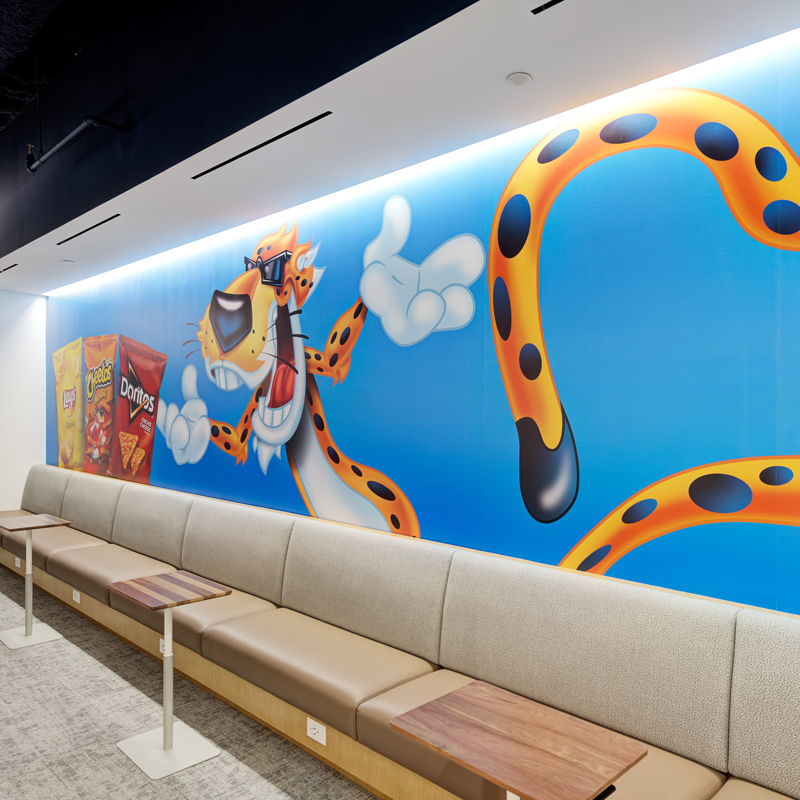 A vibrant mural depicting Chester the Cheetah cartoon character painted on a wall, showcasing bright colors and playful design.