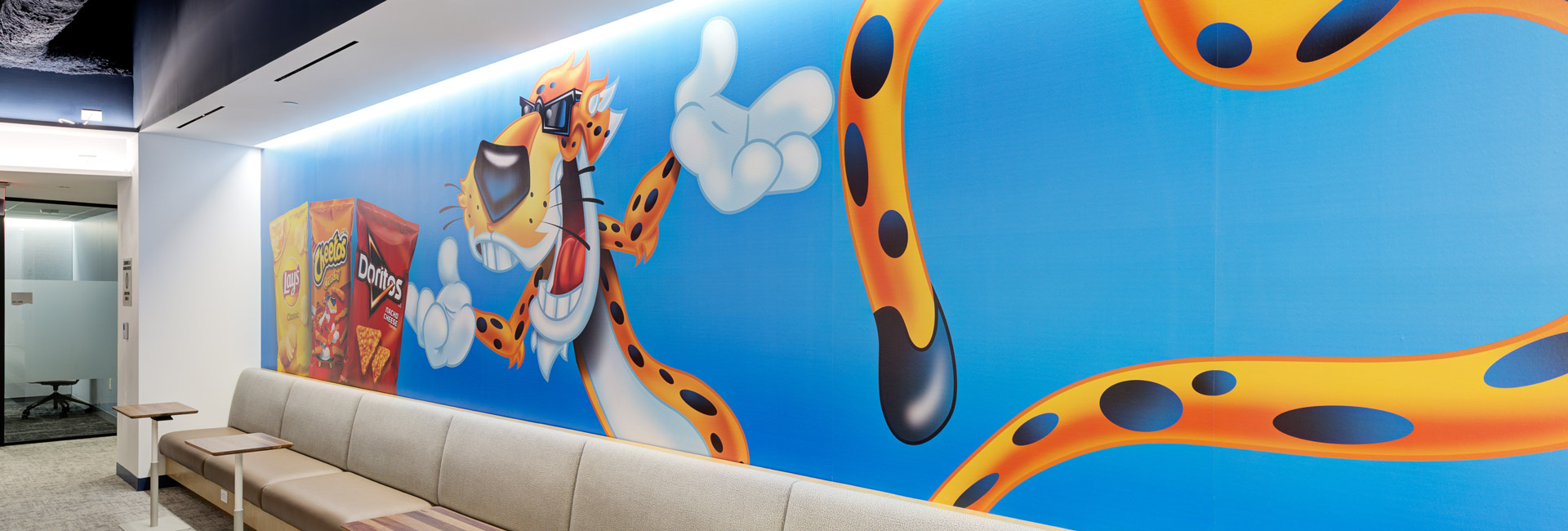 A vibrant mural depicting Chester the Cheetah cartoon character painted on a wall, showcasing bright colors and playful design.