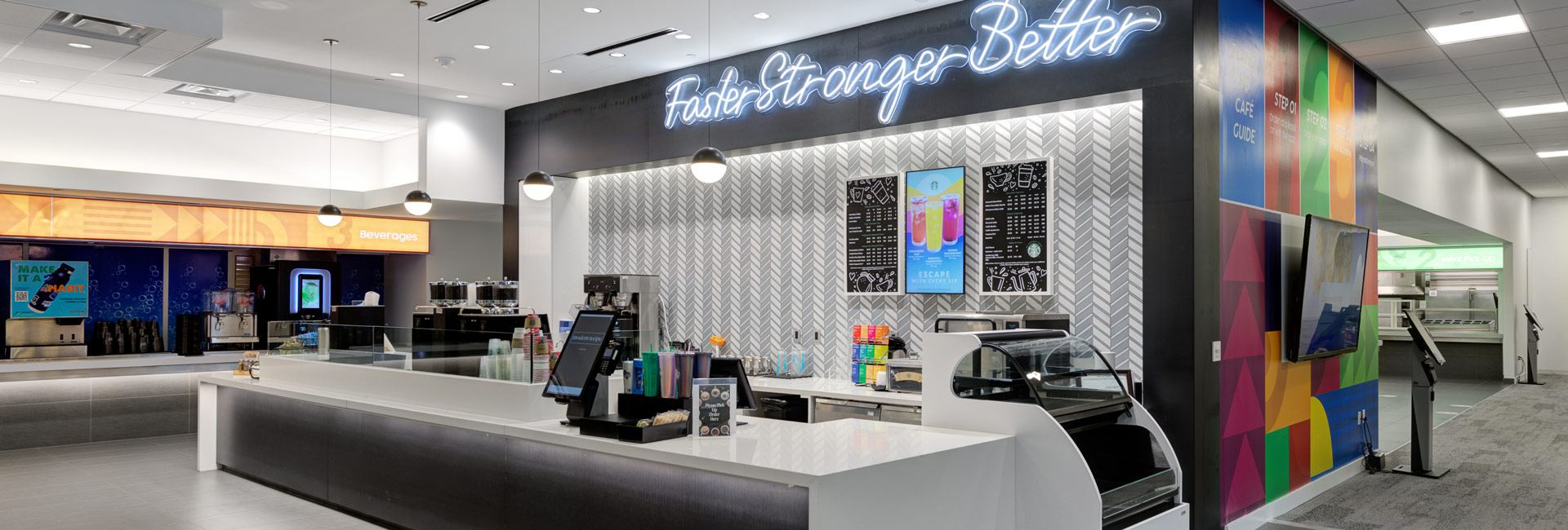 A vibrant cafeteria featuring a checkout counter and a prominent sign, creating an inviting atmosphere for visitors.