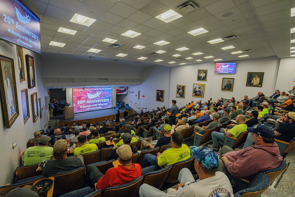 A group of workers listening to a presentation in an auditorium.