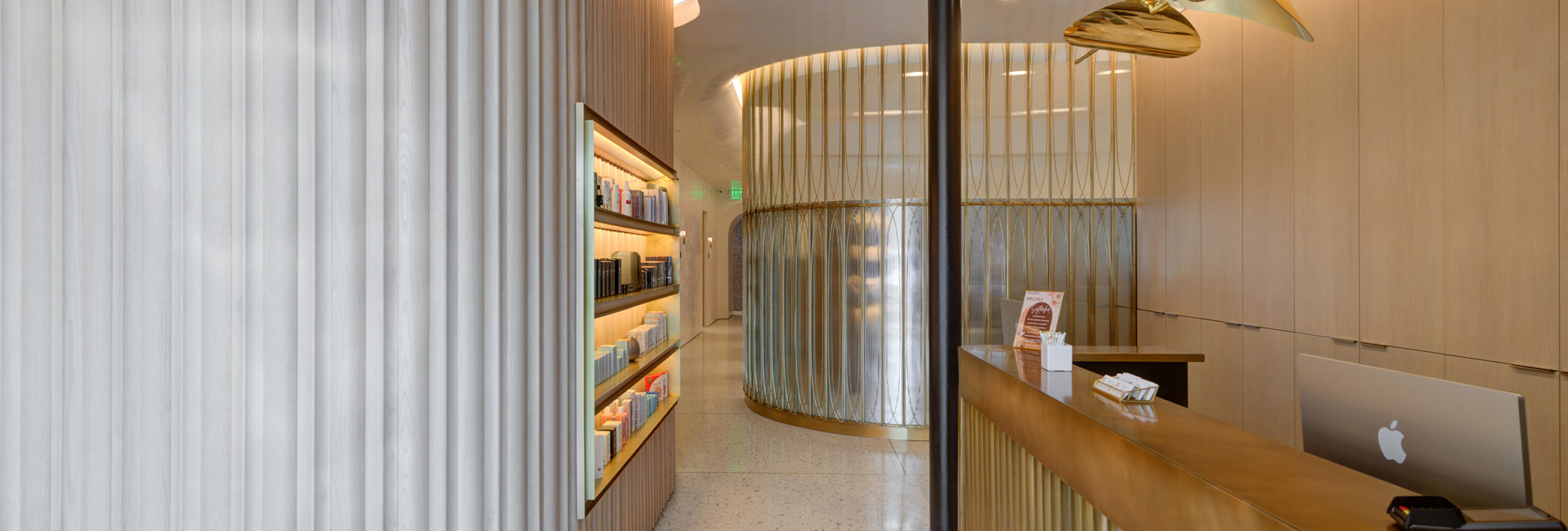 A sleek reception area featuring modern white and gold decor, creating an elegant and inviting atmosphere.