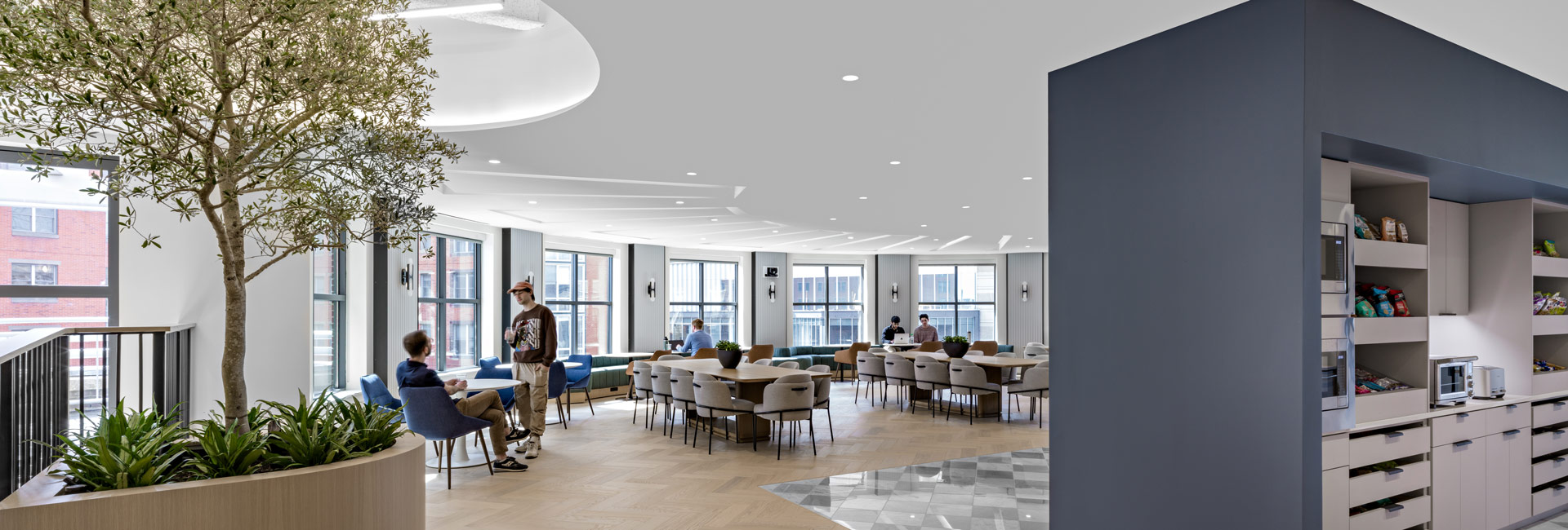 A spacious area of an office featuring high ceilings and an open layout, inviting natural light and movement.
