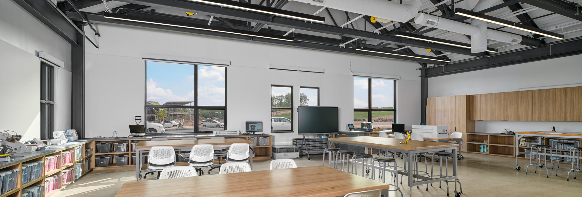 A classroom featuring rows of desks and tables arranged for student use.