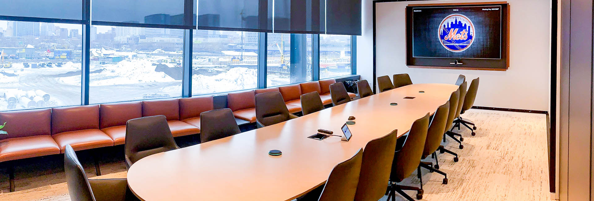 Citi Field The Hub: A modern conference room equipped with a large screen and multiple chairs set up for a meeting.