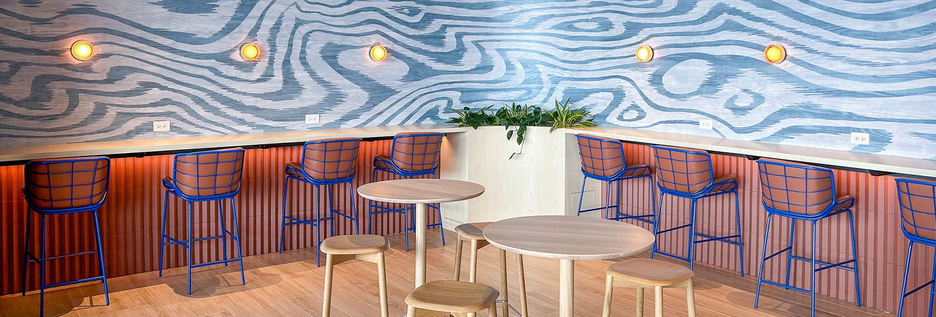 Citi Field The Hub: A lively bar showcasing blue and orange walls and chairs, designed to create a vibrant and energetic ambiance.