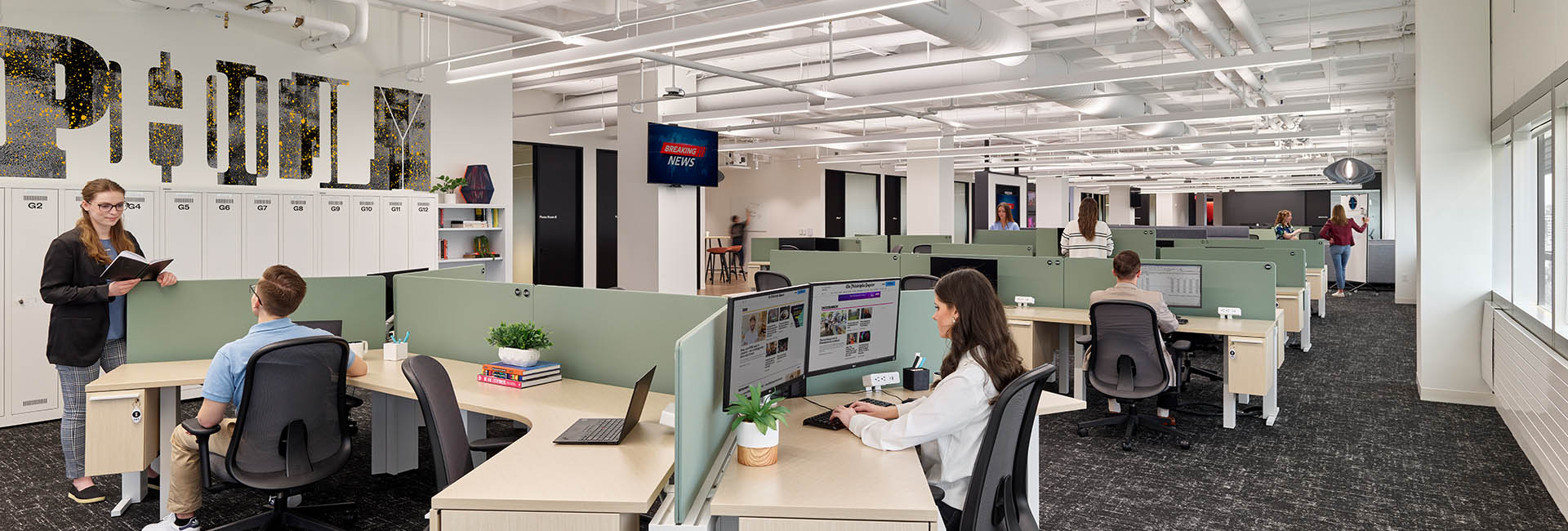 Interior with desks and mint green accent on light wood desks of The Philadelphia Inquirer corporate HQ built out by Structure Tone Philadelphia