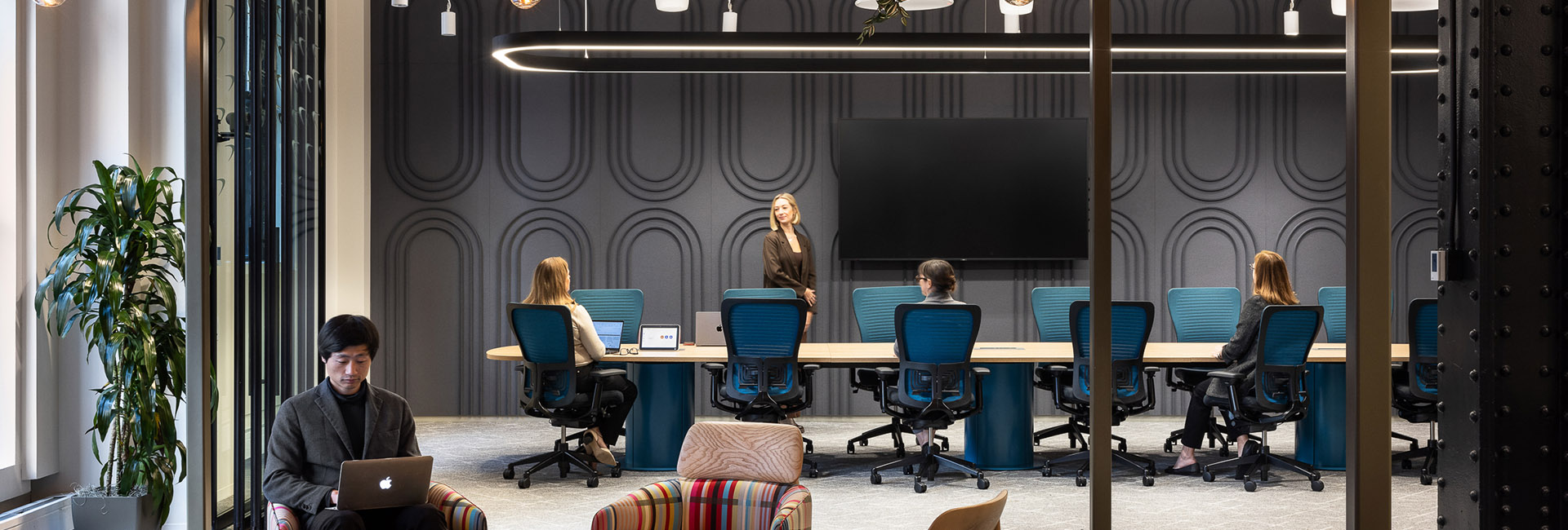 a meeting room in grey with turquoise accents and wood table