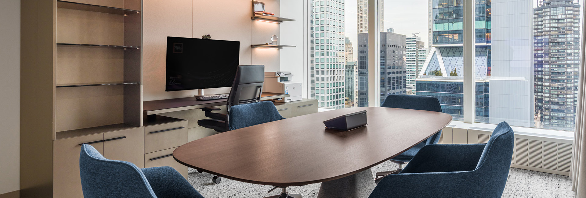 An office with a conference desk and big windows