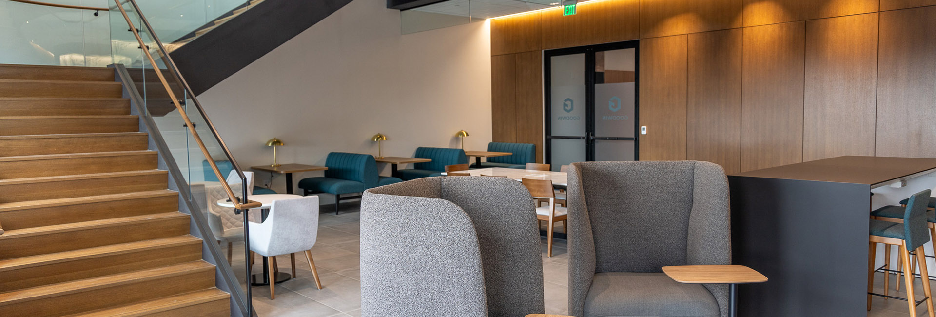 Goodwin Proctor dining area with modern seating and stair case built by Structure Tone