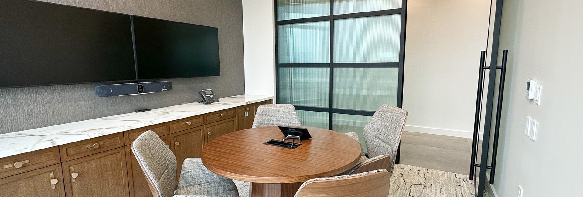 Goodwin Proctor small conference room with round table and grey chairs built by Structure Tone