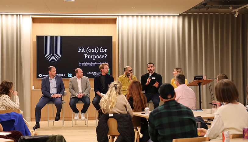 Fit Out For Purpose Article people at a conference with speaker in front with presentation